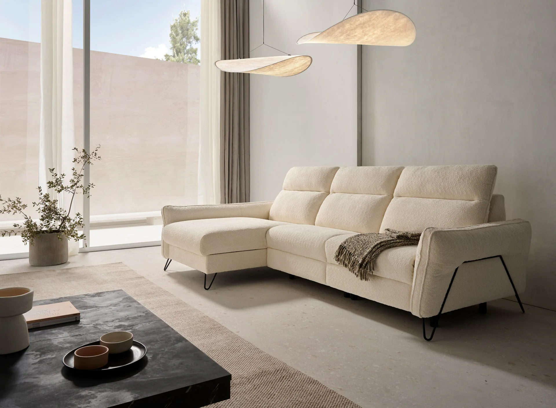 Sofá relax Einar de Acomodel con chaiselongue en un salón luminoso